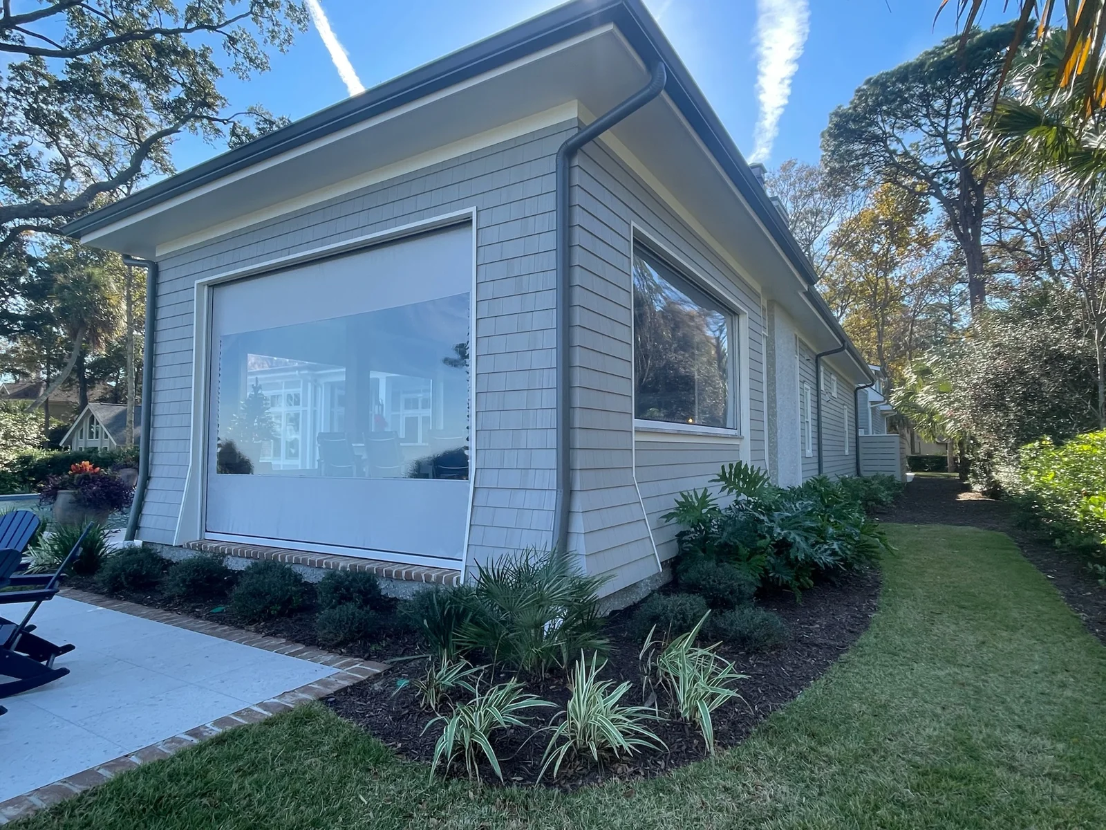 Fenetex clear vinyl screen lowered over a residential porch opening